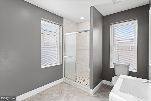 bathroom featuring toilet, an enclosed shower, and sink