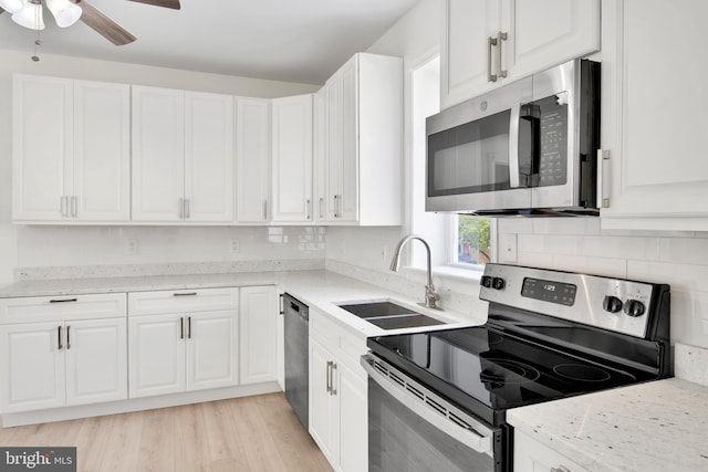 kitchen featuring appliances with stainless steel finishes, white cabinetry, and sink