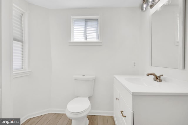 bathroom featuring wood-type flooring, vanity, and toilet