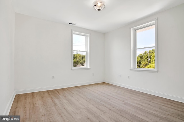 spare room featuring plenty of natural light and light hardwood / wood-style floors