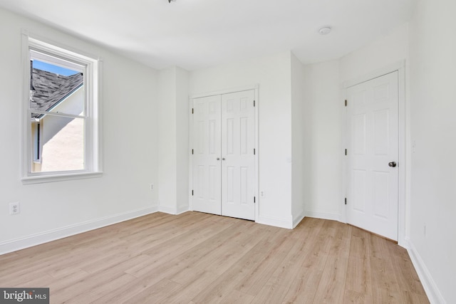 unfurnished bedroom featuring light wood-type flooring and a closet