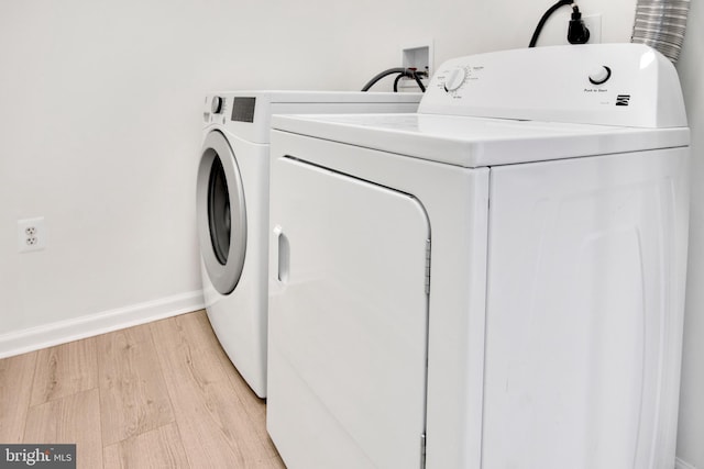 laundry room featuring light wood-type flooring and separate washer and dryer