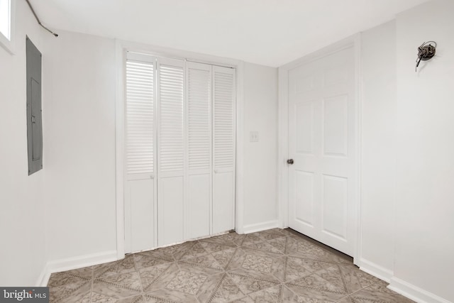 unfurnished bedroom featuring electric panel and a closet