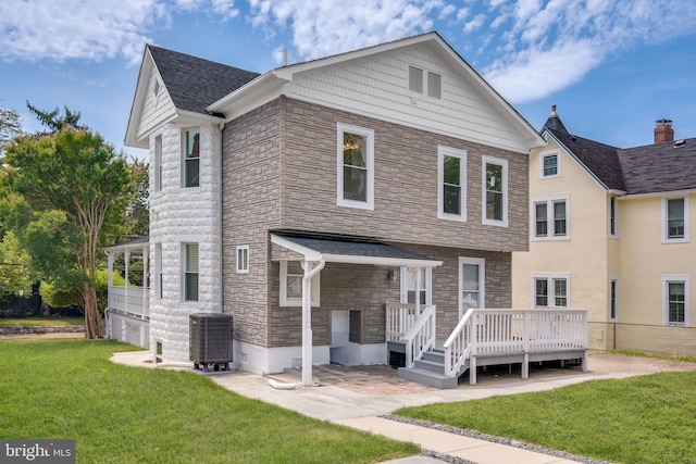 view of front property featuring cooling unit, a front lawn, and a deck