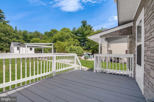 wooden deck featuring a lawn