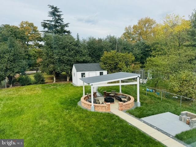 view of yard with a patio area, a fire pit, and a storage shed