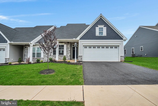 craftsman-style home featuring a front yard, central AC, and a garage