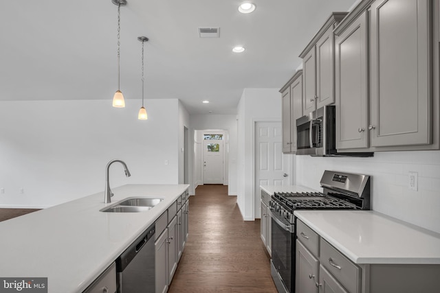 kitchen featuring stainless steel appliances, sink, pendant lighting, gray cabinets, and dark hardwood / wood-style floors