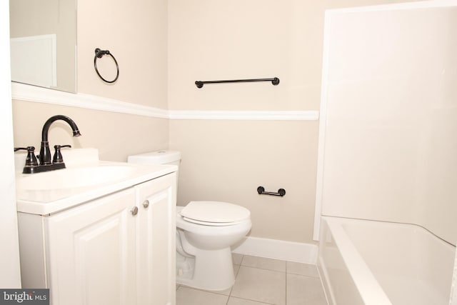 bathroom with tile patterned flooring, toilet, vanity, and baseboards