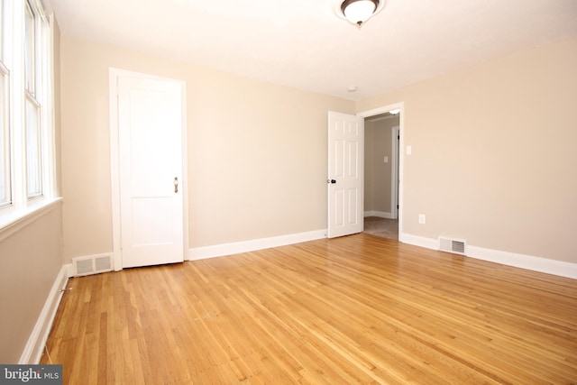 unfurnished bedroom featuring visible vents, light wood-style flooring, and baseboards