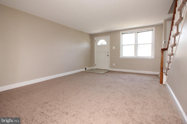 entryway with light colored carpet and baseboards