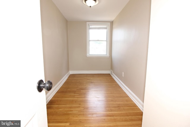 spare room featuring baseboards and light wood-style floors