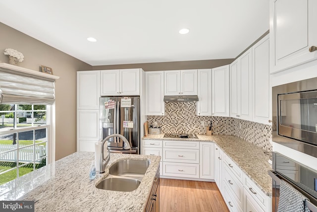 kitchen featuring appliances with stainless steel finishes, sink, light stone counters, and white cabinets