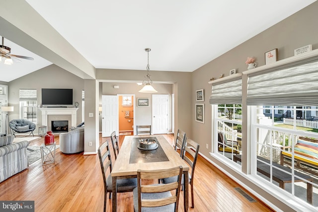 dining space featuring ceiling fan, vaulted ceiling, and light hardwood / wood-style floors