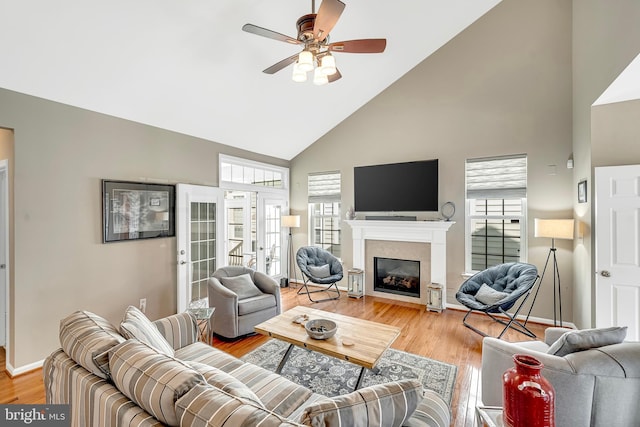 living room with light hardwood / wood-style floors, high vaulted ceiling, and ceiling fan