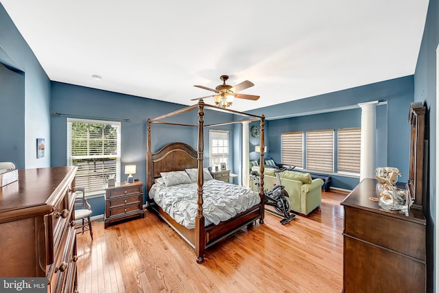 bedroom featuring multiple windows, decorative columns, ceiling fan, and light hardwood / wood-style flooring