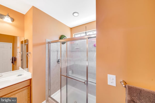 bathroom featuring vanity and a shower with door