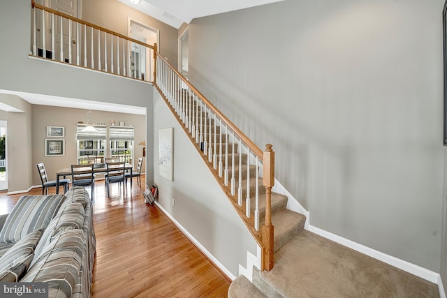 stairway featuring hardwood / wood-style floors and a towering ceiling