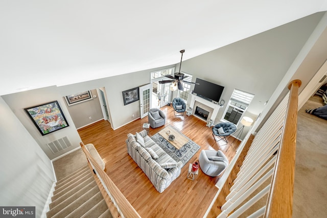 living room with hardwood / wood-style floors, high vaulted ceiling, and ceiling fan