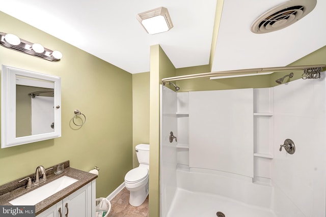 bathroom featuring toilet, vanity, tile patterned flooring, and a shower