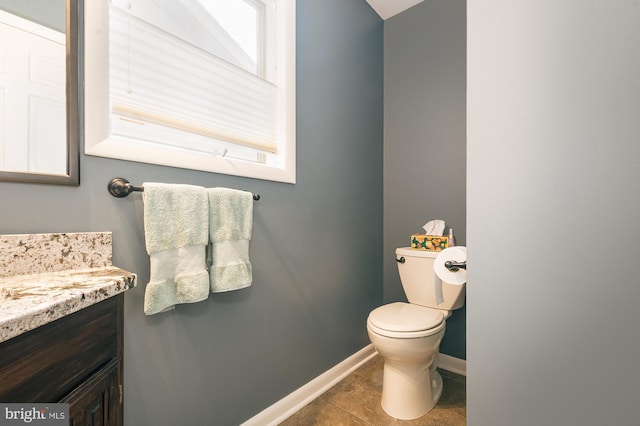 bathroom with tile patterned flooring, vanity, and toilet