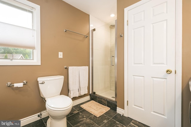 bathroom featuring toilet and a shower with door