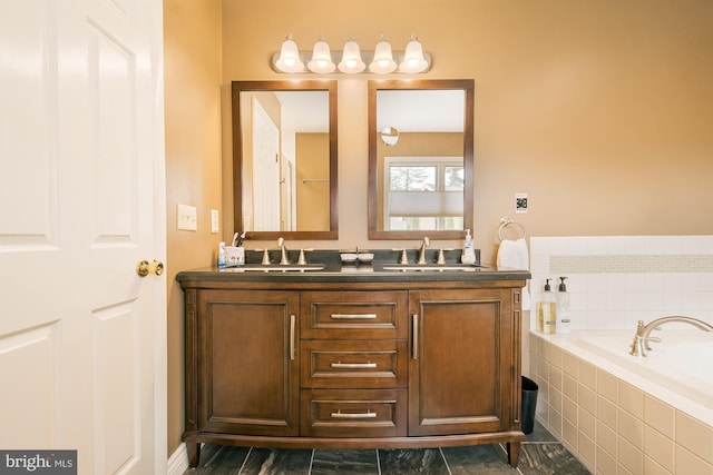 bathroom featuring a relaxing tiled tub and vanity