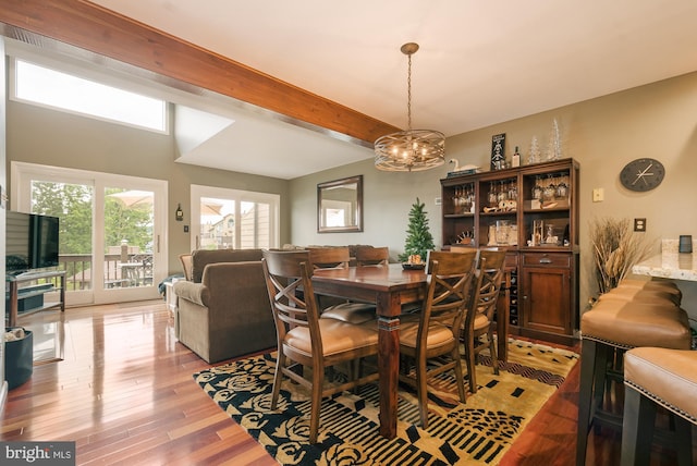 dining room with beam ceiling, light hardwood / wood-style floors, and a notable chandelier