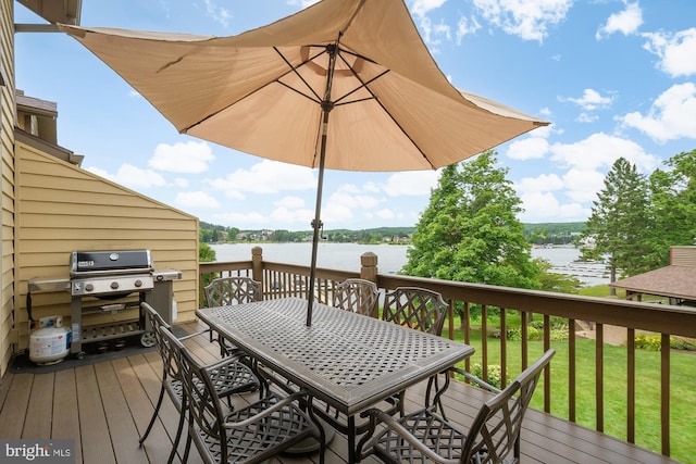 wooden deck with a yard and a water view