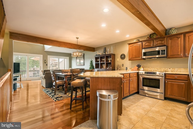 kitchen featuring kitchen peninsula, appliances with stainless steel finishes, light stone counters, beamed ceiling, and hanging light fixtures