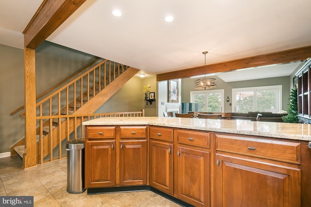 kitchen with light stone counters, beamed ceiling, hanging light fixtures, and a notable chandelier