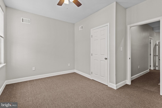 carpeted spare room featuring ceiling fan