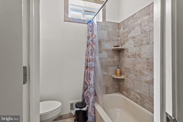 bathroom with shower / bath combo with shower curtain and toilet