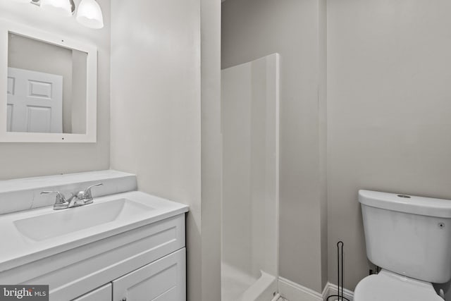 bathroom with a shower, vanity, and toilet