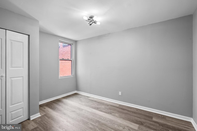 unfurnished bedroom with hardwood / wood-style flooring and a closet