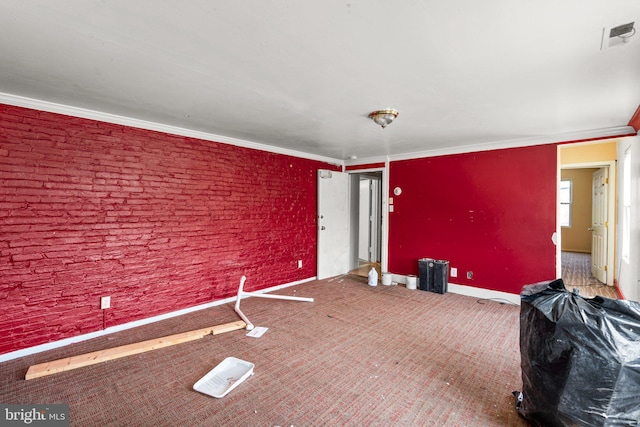 dining space with carpet floors, crown molding, and brick wall