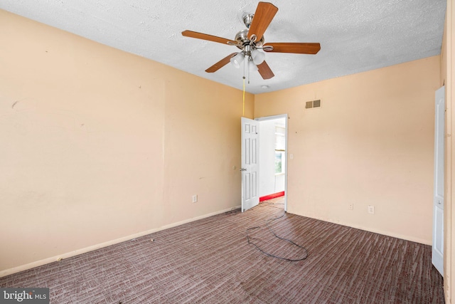 empty room featuring carpet flooring, ceiling fan, and a textured ceiling