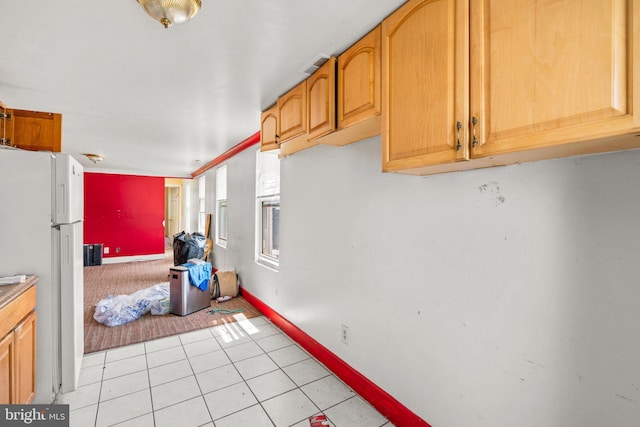 kitchen featuring light tile patterned floors and white fridge