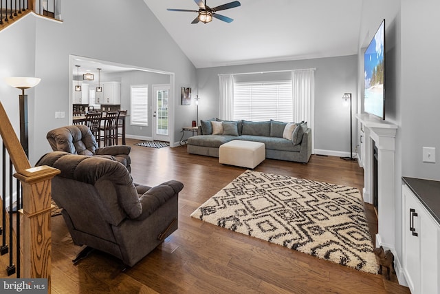 living room with dark hardwood / wood-style floors, high vaulted ceiling, and ceiling fan