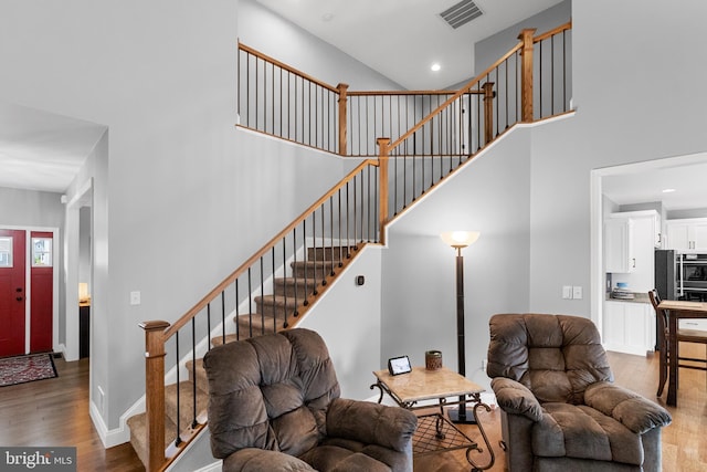 living room featuring hardwood / wood-style flooring and a high ceiling