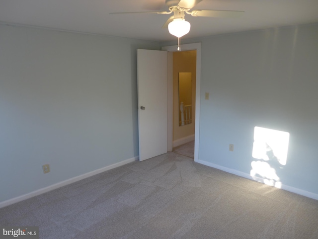 carpeted spare room with ceiling fan