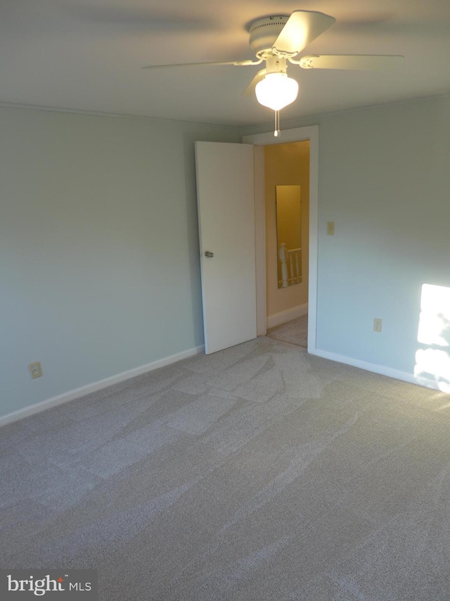 empty room featuring ceiling fan and light colored carpet