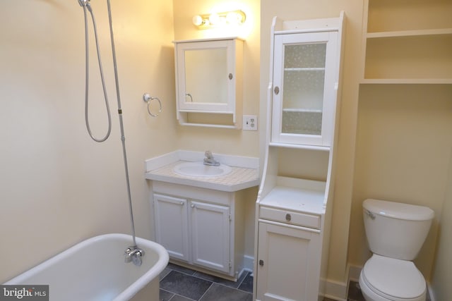 bathroom with tile patterned flooring, a bathtub, vanity, and toilet