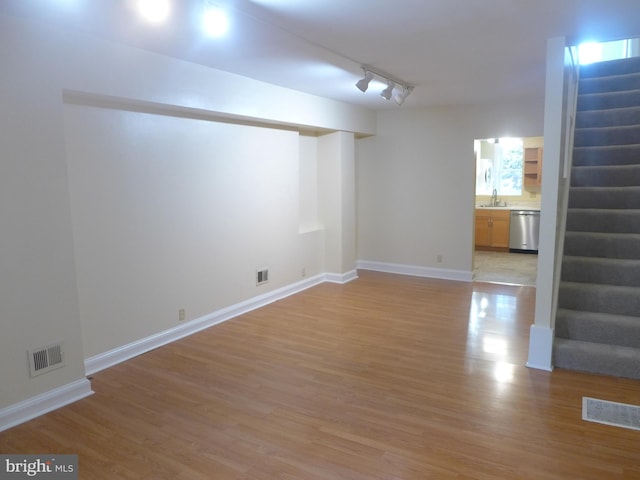 spare room with rail lighting, light wood-type flooring, and sink