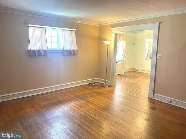 spare room featuring wood-type flooring and crown molding