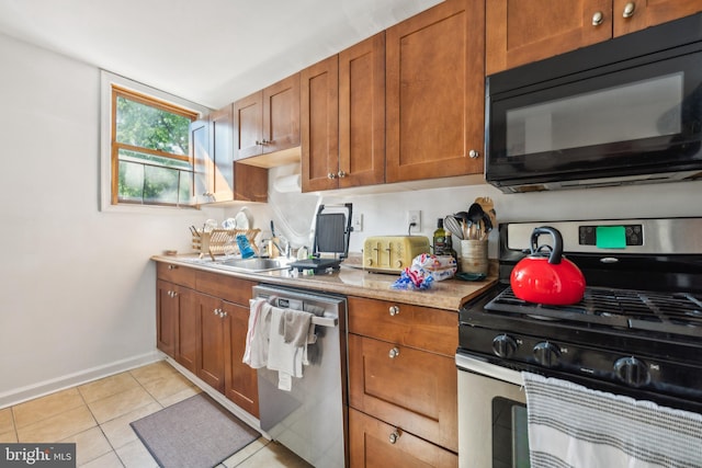 kitchen with appliances with stainless steel finishes, light tile patterned floors, and sink