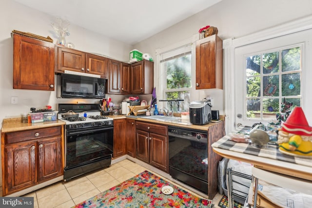 kitchen featuring black appliances, light tile patterned flooring, and sink