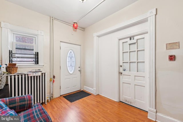 entrance foyer with wood-type flooring and radiator heating unit