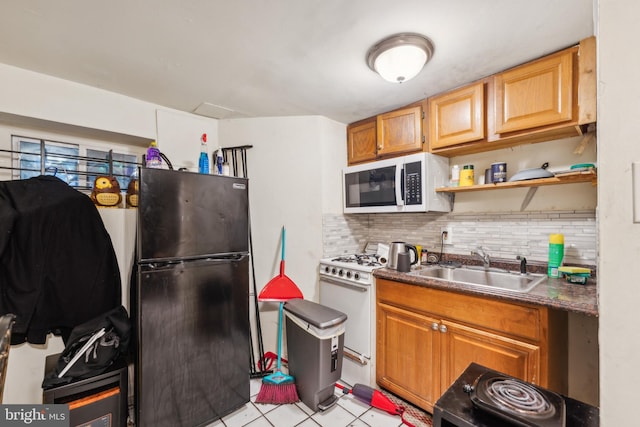 kitchen featuring light tile patterned flooring, sink, white appliances, and backsplash