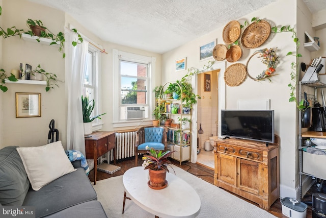 living room with cooling unit, a textured ceiling, and radiator